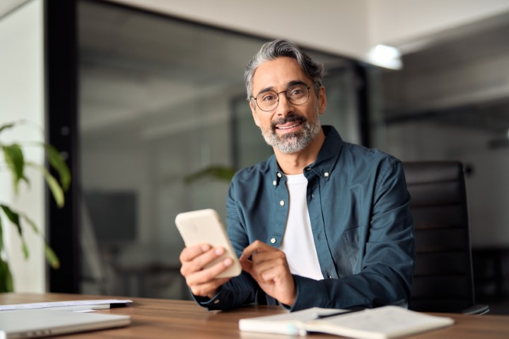 Mann mit Handy im Büro